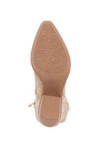 Botín de ante beige hasta el tobillo con suela de goma texturada, puntera afilada y un discreto detalle de costura. Cierre con cremallera en la parte trasera para facilitar su uso.