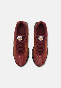 Maroon i narančasti Nike Air Max tenisice s uzorkom od mrežaste tkanine, crnim potplatom i okruglom oznakom na jeziku.
