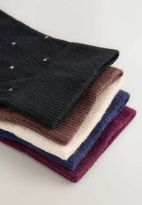 Fünf gestrickte Socken in verschiedenen Farbtönen: schwarz mit rosa Punkten, kastanienbraun, creme, blau und dunkel lila. Weiche Textur, gerippte Gestaltung.