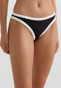 Czarne majtki od bikini z kontrastową, białą lamówką. Charakteryzują się gładką fakturą, niskim stanem oraz minimalistycznym krojem.