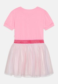 Różowa bawełniana sukienka z krótkim rękawem, z błyszczącym różowym pasem i warstwową, przezroczystą sukienką z lekkiego różowego tiulu. Widok z tyłu.