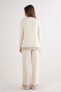 Krémová souprava na doma s dlouhými rukávy a krajkovými detaily na lemu a manžetách kalhot. Měkká, lehká tkanina, uvolněný střih.