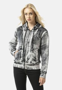 Hooded zip-up sweatshirt in black and white with a textured, abstract pattern and handwritten accents. Features front pockets and ribbed cuffs.