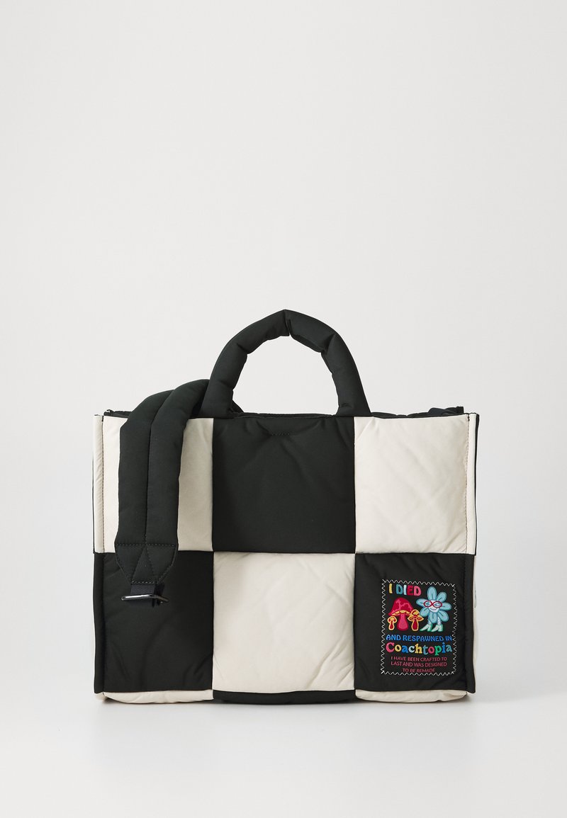 Geantă tote quilted în negru și crem, cu mânere căptușite și un patch cu text brodat și desene colorate pe o parte.
