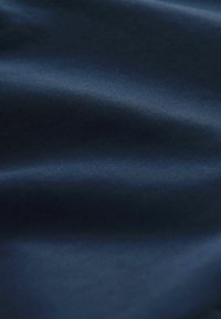 Material albastru închis cu o textură fin, netedă, cu nervuri fine și pliuri delicate care creează umbre moi.