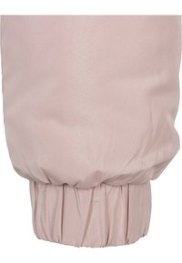 Puffig rosa ärm med insamlad manschett, gjord av mjukt tyg med en len textur. Diskret glans förstärker dess utseende.