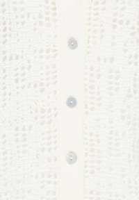 Tissu blanc en maille avec une rangée verticale de quatre boutons ronds translucides attachés le long d'une patte boutonnée côtelée.