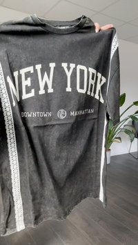 Svart bomull T-skjorte med "NEW YORK" i fet hvit skrift. Har blonde detaljer på ermene og rund hals. Avslappet passform.
