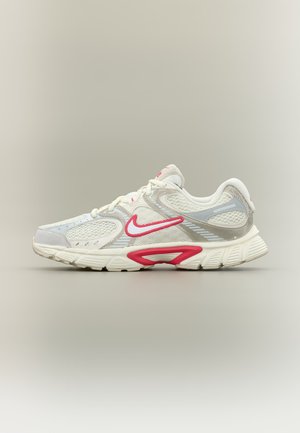 Hvid og grå Nike løbesko med røde detaljer, meshpaneler og en polstret sål vist i sideprofil på en neutral baggrund.