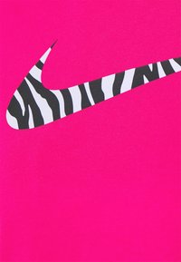 Rosa tyg med en framträdande svart och vit zebra-randig Nike-logotyp, slät textur och livfull färg. Enkel och modern design.