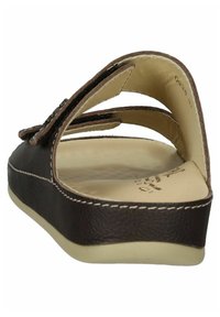 Brune lædersandal med en formet fodseng, åben design og krydsskrå remme med syningsdetaljer. Flad sål for komfort.