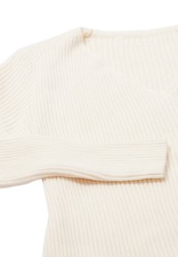 Crèmekleurige geribbelde knit lange mouwen trui met een V-halslijn, plat gevouwen op een witte achtergrond.