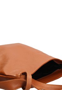 Bruin leren totebag met een gestructureerd oppervlak, voorzien van een ritssluiting en een enkele verstelbare schouderband. Binnenkant gevoerd in het zwart.