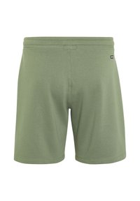 Grüne Sportshorts aus weichem Material, mit einem elastischen Bund und einem kleinen Logotag an der Seite. Schlichtes Design, keine Muster.