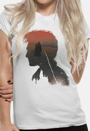 Hvid kortærmet t-shirt med et grafisk silhuetdesign af en figur mod en rød og sort gradient baggrund.