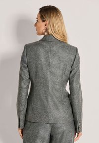 Op maat gemaakte grijze pinstripe blazer van textiele stof, met een klassieke kraag, gestructureerde schouders en knoopaccenten op de mouwen.