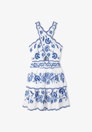 Robe en coton blanc avec broderies florales et paisley bleues, bords festonnés, bretelles croisées et jupe à volants superposés.