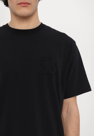 Svart bomulls t-skjorte med korte ermer, med en tonal brodert "B"-logo på venstre brystsomme område. Glatt tekstur.