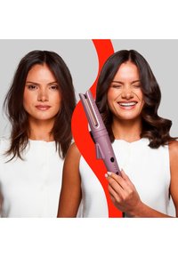 En rosa krølltang med gyldne plater, med håndtak og kontrollknapper, ved siden av en kvinne med rett hår på den ene siden og voluminøse krøller på den andre.