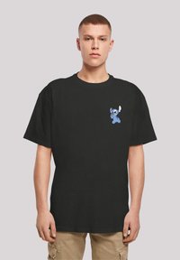 Black cotton t-shirt featuring a blue cartoon character on the left chest. Short sleeves and a relaxed fit design.
