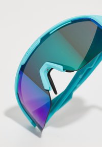 Turquoise sports sunglasses with mirrored gradient lenses, wraparound design, and black accents on the nose piece.
