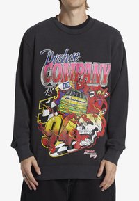 Black sweatshirt featuring bold, colorful graphic print with flames, a race car, and skull. Ribbed neckline and cuffs. Loose fit.