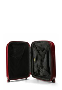 Maleta dura roja con forma curva, que cuenta con un interior geométrico negro, correas cruzadas y un bolsillo con cremallera en un lado.