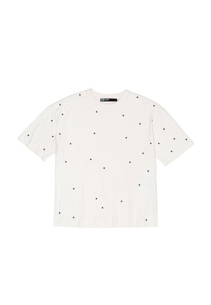 Biała bawełniana koszulka z luźnym krojem, z małymi czarnymi kropkami równomiernie rozmieszczonymi na całej powierzchni. Krótkie rękawy, okrągły dekolt.