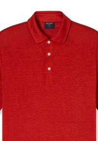 Rode polo shirt gemaakt van textuurstof, met een klassieke kraag, vier knopen en een subtiele heatherpatroon. Merklabel zichtbaar binnenin de kraag.