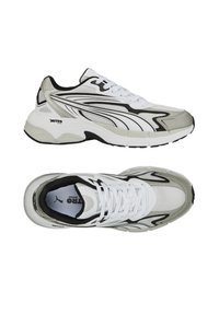 Atletické boty s kulatou špičkou, převážně bílé s šedými a černými akcenty, vyrobené z prodyšných a syntetických materiálů, s texturovanou podrážkou.