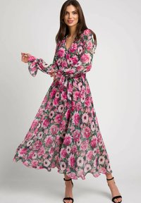 Sukienka maxi w zwiewnym materiale z intensywnym kwiecistym wzorem, w tym różowe róże i białe anemony. Długie rękawy z rozwianymi mankietami.