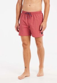 Bañadores de hombre en color rosa, hechos de tela ligera, con cintura ajustable y bolsillo lateral con un acento de logo.