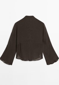 Blusa trasparente marrone scuro con maniche lunghe ampie, dettaglio della cucitura posteriore e polsini leggermente svasati su sfondo bianco.