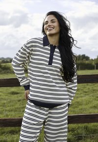 Długi rękaw, zdekoltowana bluzka w paski oraz pasujące spodnie w kolorze kremowym i granatowym. Teksturowana tkanina z kołnierzykiem, zapięciem na guziki oraz elastycznym pasem.