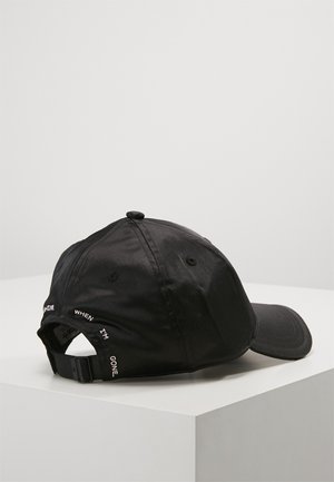 Black adjustable baseball cap with embroidered white text around the back opening, placed on a white surface against a plain background.