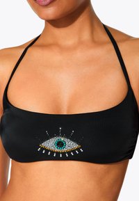 Zwarte bikini-top met een decoratief oogontwerp gemaakt van kleurrijke rhinestones. Voorzien van dunne bandjes, een gladde textuur en een aansluitende vorm.