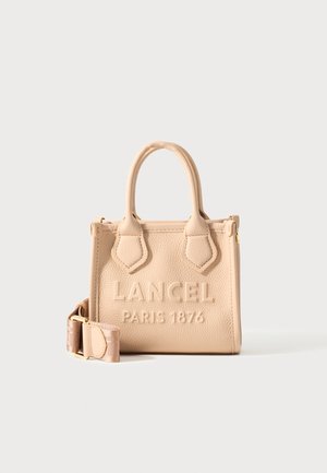 Béžová kožená kabelka s textúrou a dvoma rúčkami, s vyrazeným nápisom "Lancel Paris 1876" vpredu a s odnímateľným ramenným popruhom v zlatej farbe.