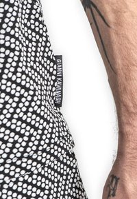 Tela de patrón en blanco y negro con un diseño de puntos. Incluye una etiqueta tejida con "Gianni Kavanagh" en un lado.