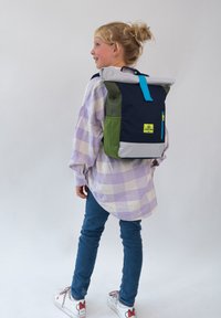 Kék és zöld roll-top hátizsák szürke részletekkel, elülső zsebbel és élénk kék cipzárral. Tartós anyagból készült, strapabíró kialakítással.