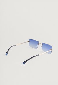 Γυαλιά ηλίου με τετράγωνο μεταλλικό χρυσό σκελετό, μπλε γυαλιστερές φακοί, μαύρο πλαστικό βραχίονα και διαφανή πλάγια στηρίγματα στη μύτη.