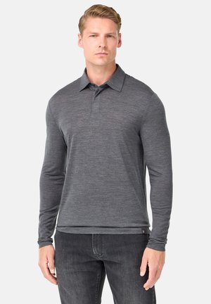 Polo de manga larga en gris oscuro, hecho de una tela suave, con un collar clásico y una botonadura, combinado con jeans oscuros.