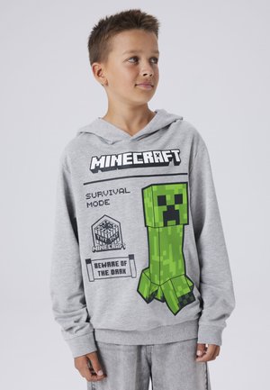 Grijze hoodie met een voorzijde print van een groene pixelated creeper uit Minecraft, met de tekst "Survival Mode" en "Beware of the Dark."