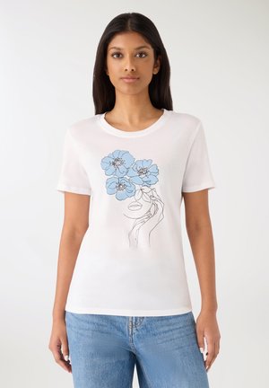 Biała bawełniana koszulka z niebieskim kwiatowym wzorem oraz liniowym rysunkiem twarzy i dłoni. Krótkie rękawy i okrągły dekolt.