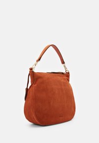 Polttavan oranssinvärinen mokkanahkainen käsilaukku, jossa kaareva siluetti, lyhyt nahkainen kahva ja kullanväriset metalliosat. Sileä pinta.