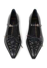 Black leather flat shoes with pointed toes, featuring a lace-up design with gold-tone eyelets and a strap with a metallic buckle.