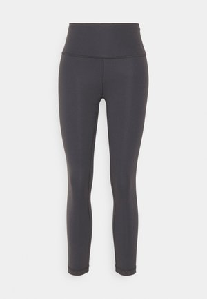 Schwarze sportliche Leggings aus dehnbarem Material, mit hoher Taille, schlanker Silhouette und nahtlosem Design ohne Muster.