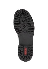 Semelle en caoutchouc noir avec un motif de profondeur, comprenant des designs hexagonaux et floraux ; marquée avec "rieker" en rouge près du talon.