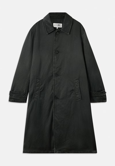 Μαύρο παλτό από υφασμένο ύφασμα, με ανοιχτό γιακά, κλείσιμο με κουμπιά και δύο πλαϊνές τσέπες. Μακριά, ίσια γραμμή με λεπτομέρειες στους καρπούς.