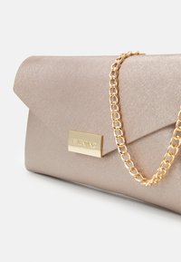 Clutch bag in metallic taupe fabric with a fold-over flap, gold chain handle, and gold hardware logo plate. Smooth, textured finish.