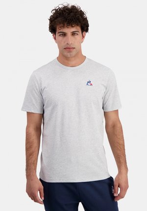 T-shirt in cotone grigio chiaro con colletto rotondo, maniche corte e un piccolo logo ricamato sul lato sinistro del petto. Texture morbida e design casual.